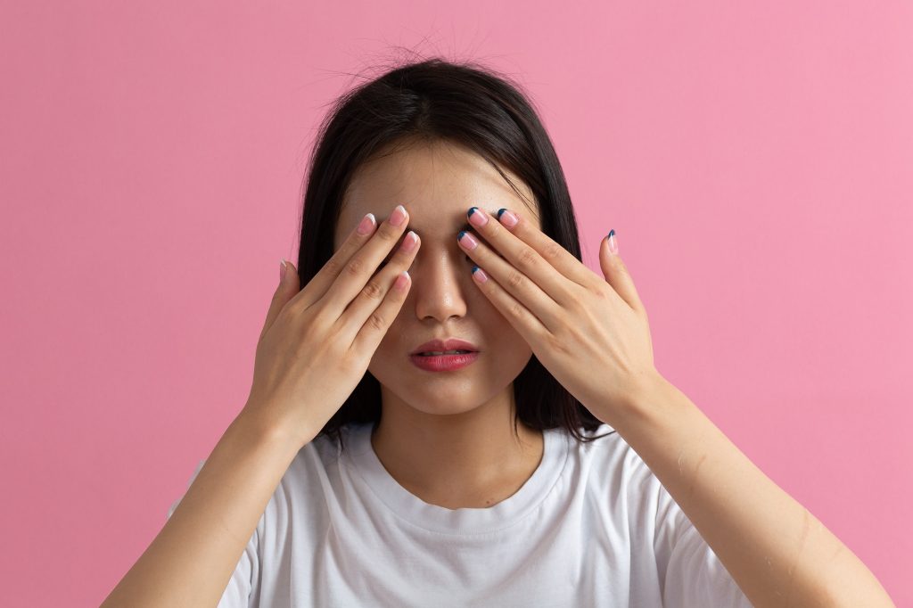 Asian shy young woman close her eyes and face by hands. Blindness and Vision